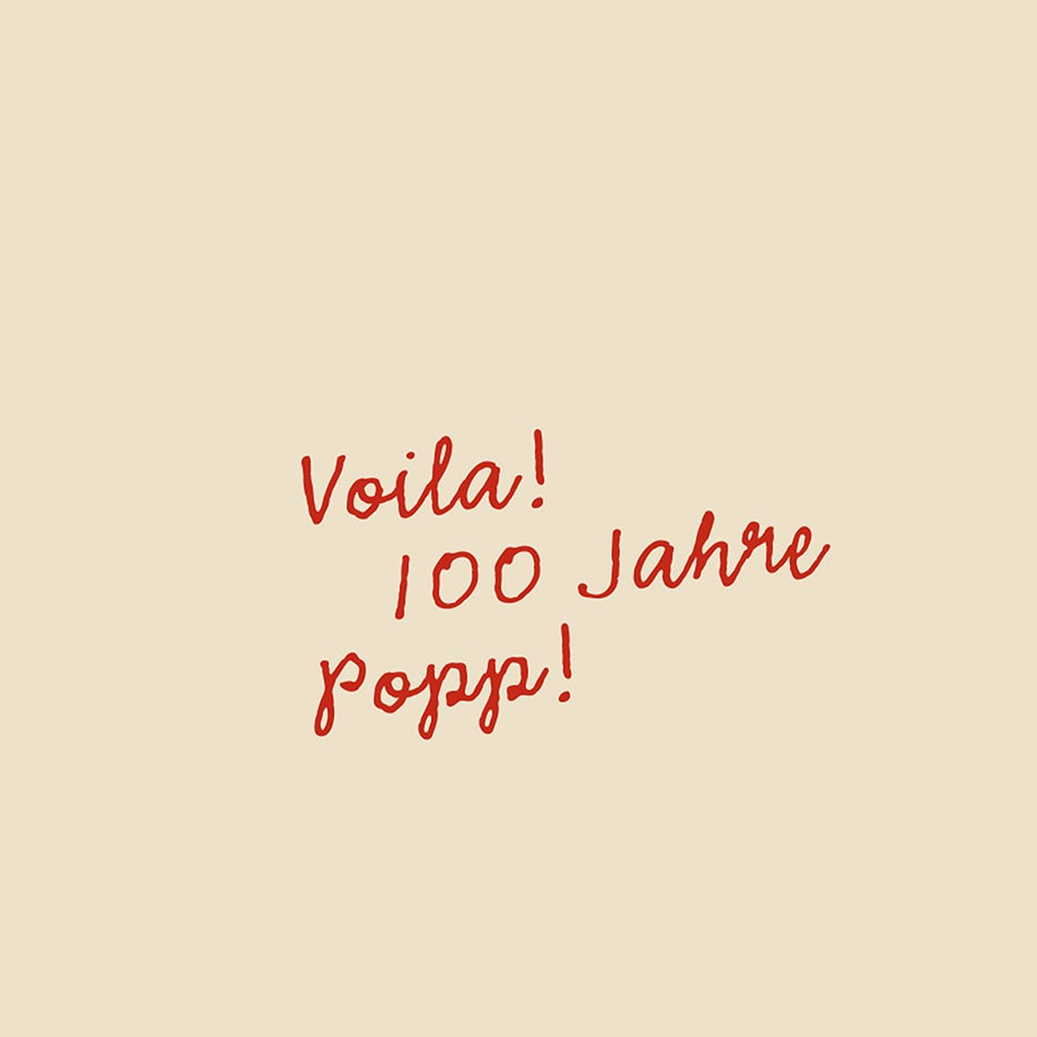 Ein roter Schriftzug „Voila! 100 Jahre Popp!"
