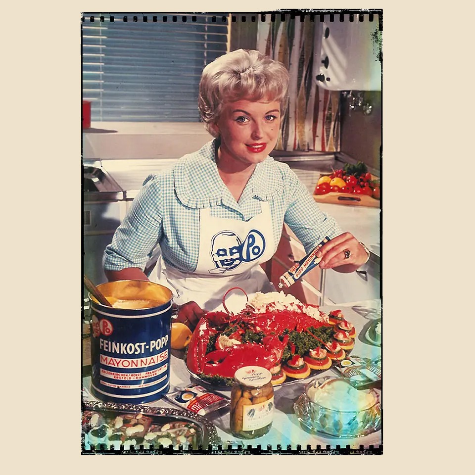 altes Werbeplakat von Popp Feinkost mit einer Hausfrau, die essen zubereitet.
