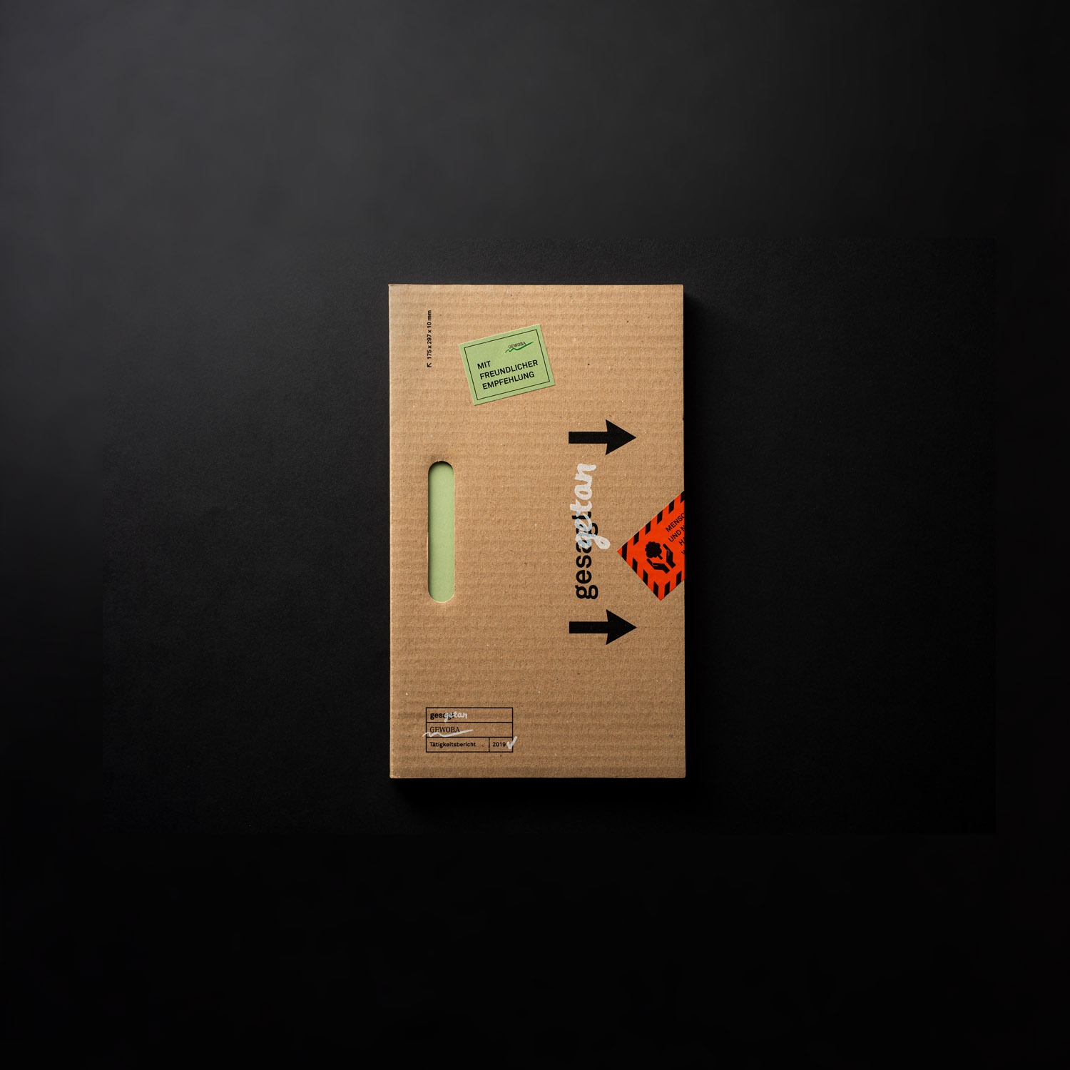 Buch mit einem Umschlag aus Wellpappe und Aufkleber als Verschlusselement. POALRWERK hat für die Kennzahlen von GEWOBA ein Design und Produktion für den CSR-Report übernommen.